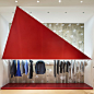 Tokujin Yoshioka installs red triangles at Issey Miyake store : Crimson aluminium triangles hang above garments and in front of windows at Japanese designer Tokujin Yoshioka's latest store for Issey Miyake in Tokyo