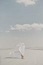 "Human Standing In Desert With A White Flow Sheet Blowing In The Wind To The Side" by Stocksy Contributor "Itla"