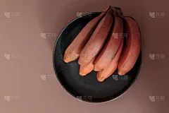 米色桌子上一串成熟的有机红色香蕉。水果的背景。我是红达卡。含有更多的-胡萝卜素和维生素C。