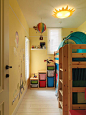 [儿童房设计 家居布置] 儿童房的墙面是淡黄色，很温馨，太阳吸顶灯，以及墙角的一些玩具收纳盒.