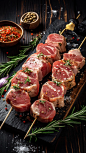 Various raw pork neck skewers are arranged on a dark background, accompanied by rosemary, sea salt, garlic and spices.