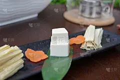 豆腐和豆腐竹叶和胡萝卜片在黑色盘子上的火锅