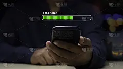 一名男子正在用智能手机下载应用程序并等待加载。