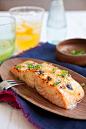 Japanese miso-glazed broiled salmon garnished with chopped scallions in a wooden serving dish.