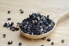 黑枸杞或黑枸杞，放在桌上的木勺里。中药中常用的草药。卫生保健的概念。