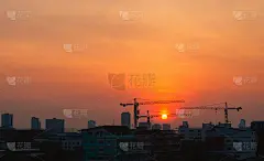 城市基础设施、居民财产建设项目的剪影景观，在早晨起重机吊起的大城市天际线与日出的黄金时刻。
