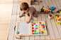 Full shot kid playing with colorful wooden toys
