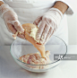 Wearing protective gloves to cover chicken with garlic and ginger paste