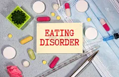 医生手里拿着一张写着饮食失调症的名片。