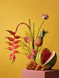 Still life of colorful, unconventional floral and fruit arrangement, with yellow background.  #photography #floralarrangments #fruitarrangements #floralsandfruit #colorfulbouquets #stilllife #stilllifephotography