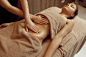 Masajista mujer mimando el estómago a mujer joven en toalla, masaje profesional. masaje y relajación, cuidado corporal y cutáneo. señora atractiva en el salón de spa