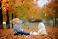 Little toddler baby boy, playing with teddy bear in the autumn p