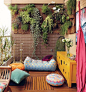 Pretty Cozy Patio: We love the cozy vibe of this deck, complete with lots of potted plants, gorgeous pillows, and a couple teeny tiny coffee tables.: 
