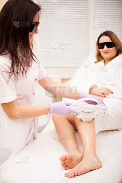 皮肤护理。腿部脱毛，在诊所做激光手术。美容师用激光去除美丽女性腿上的毛发