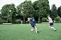 Ethnic soccer player looks for a teammate to pass to during a matchA college-age soccer player dribbles across field and looks for a teammate to pass to during a tournament. The shot is from behind him.
