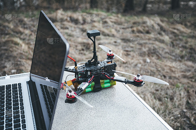FPV无人机躺在桌子上，靠近笔记本电脑和控制面板。