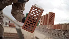 工人筑起一堵砖墙。在砖墙施工现场工作的砌砖工。砖匠正在工地上放另一排砖