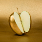 Apple cut with golden peel on gold background