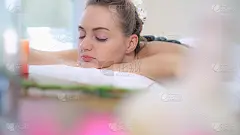 女士在水疗沙龙接受专业美容师的热石按摩治疗。奢华养生，背部压力缓解和振兴理念。