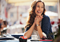 Royalty-free Image: Smiling woman drinking coffee at sidewalk cafe