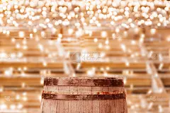 复古风格的旧深棕色橡木啤酒桶平台上的产品横幅在散景明亮的花环装饰背景