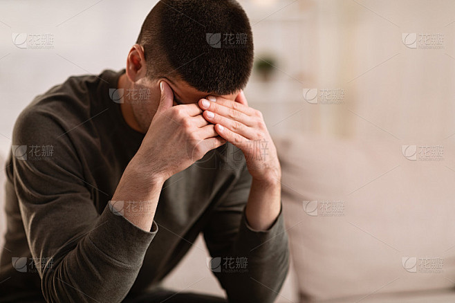 一个病人双手抱头坐在沙发上