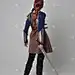 一个红头发的女孩穿着中世纪的战士服装和钢甲, 拿着一把剑的全长肖像。站在灰色工作室背景的姿势.