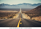 Classic panorama view of an endless straight road running through the barren scenery of the American Southwest with extreme heat haze on a beautiful sunny day with blue sky in summer