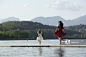 Woman and young girl skipping on dock_创意图片
