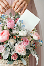 Woman holding a basket of flowers with an empty card