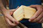 Close up of person working a boat-builders workshop, joining together two pieces of wood.