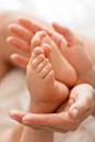 Close-up mom holding baby's feet in hands Free Photo