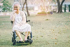 亚洲老年或老年妇女病人在轮椅上公园，健康的医疗观念强。