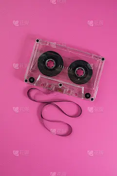 粉红色背景上放着一盘旧录音带。