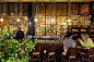 Photo bar with people and waiters with a bar counter and lots of alcohol the interior is in a modern style