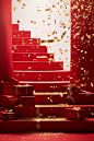 Stair case with red boxes and gold confetti falling down, in the style of monochromatic color scheme, living materials, wrapped, festive atmosphere, associated press photo, lively tableaus, curvilinear forms