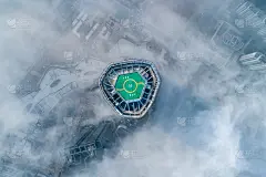 城市高层建筑屋顶上的直升机停机坪笼罩在平流雾中