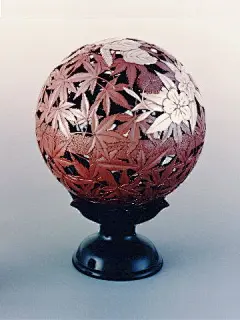 This may contain: a red and black vase sitting on top of a table