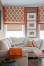 Colorful printed Roman blinds add a pop of color to this space that is picked up in other decorative accessories.