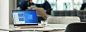 一台 Windows 10 计算机放置在桌子上，蓝色背景上显示 Windows 徽标，“开始”菜单处于打开状态，显示各应用程序
