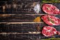 Raw meat steak on dark wooden background ready to roasting by Elena Yeryomenko on 500px