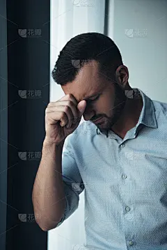 心情不好的英俊寂寞男人站在家里的窗边