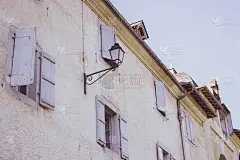 带有室外过滤灯的中世纪建筑。带有百叶窗的旧房子正面。古代建筑的概念。法国村庄的历史建筑。