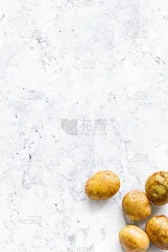 漂亮的小圆形全有机土豆，果皮孤立在白色大理石厨房顶部。
