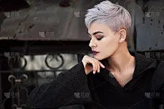 年轻美丽的时尚女孩拍摄户外附近的砖墙在房子