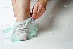 为了防止脚后跟干燥，这个女孩戴上了一个足部保湿面膜。