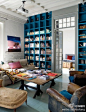 充满书香气息的地中海风格客厅，复刻的沙发，高至客厅顶端的深蓝色书架，木质沙发桌，白色方格门，林林总总的都透着一股纯朴的地中海风情。