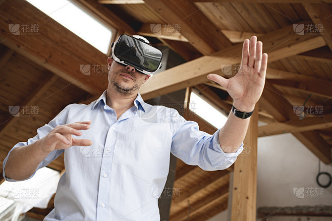 一个穿着蓝色衬衫的建筑工，用虚拟3d眼镜...