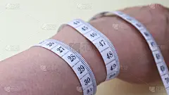绕在手腕上的卷尺。