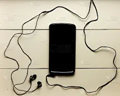 手机放在木头表面，带耳机